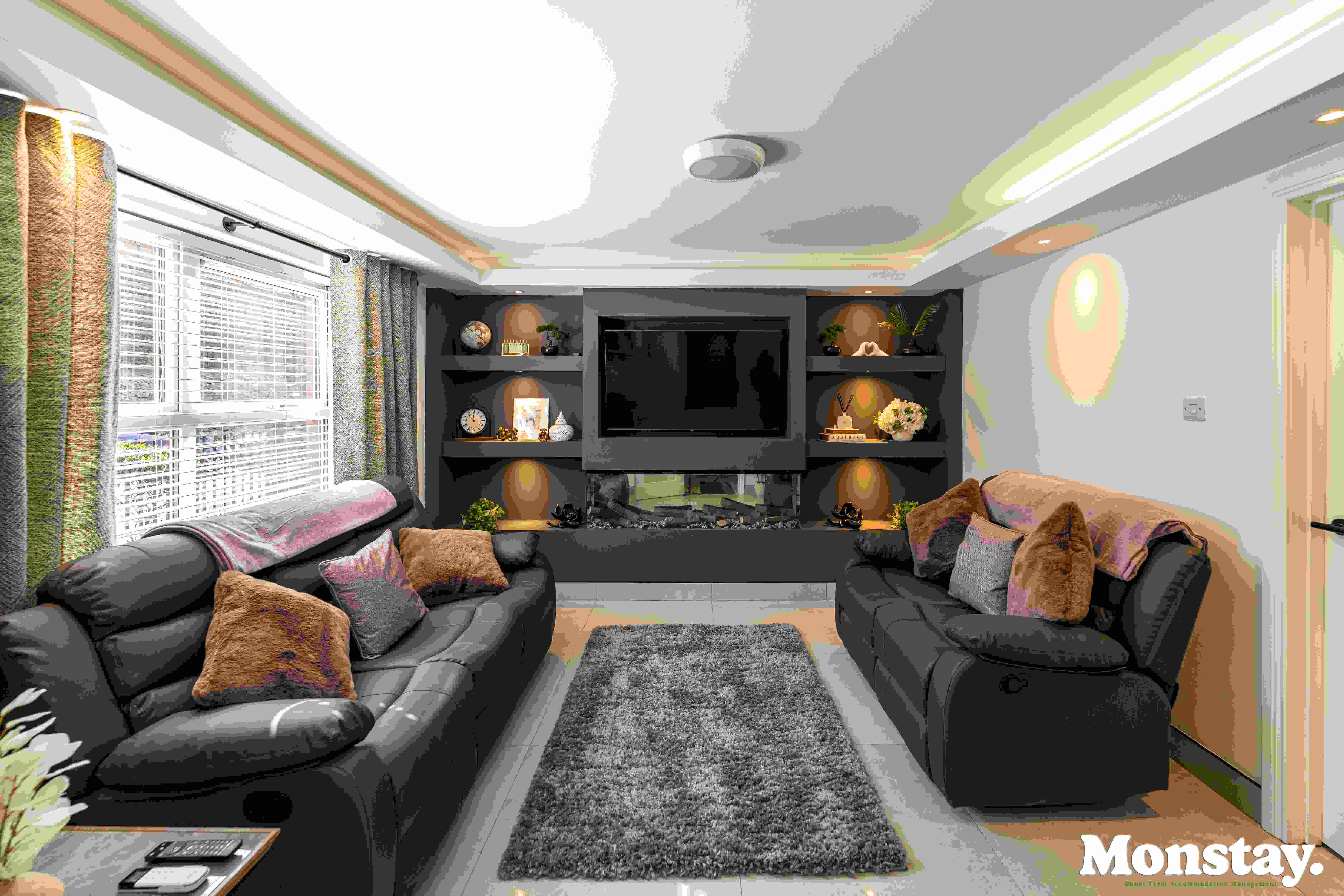 Modern lounge with media wall and inset fireplace at Walled City House Derry