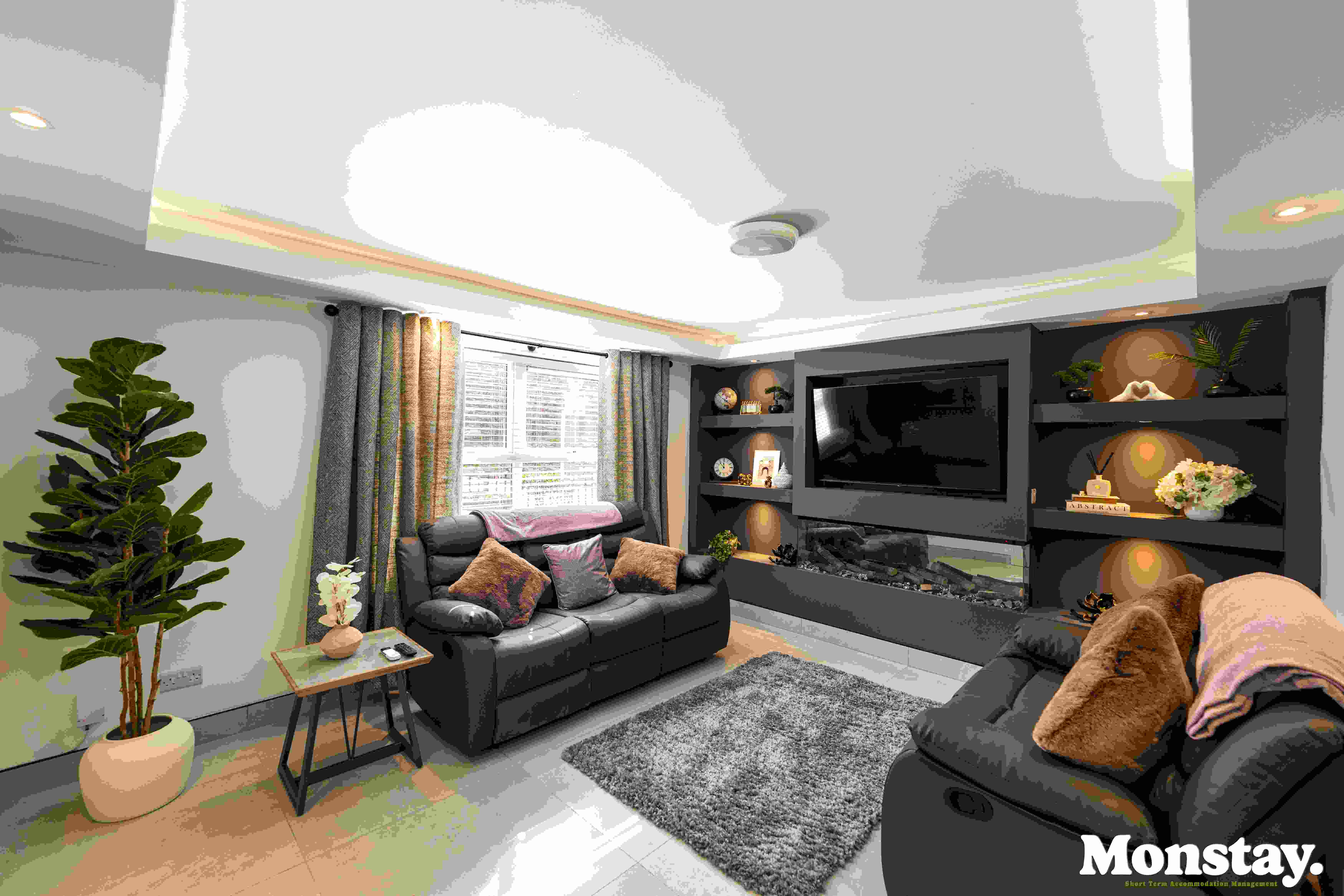 Luxury lounge area with media wall, inset fireplace and feature lighting at Walled City House Derry